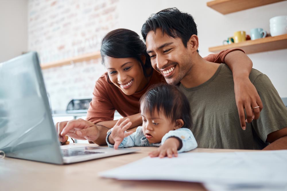 Mom, dad and child with down syndrome at computer in home
